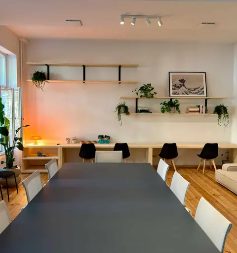 Workshopraum der Denkfabrik in Berlin mit langem Tisch, Regalen und Sofa